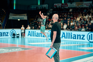 Trainer Christophe Achten im Moment des Aufschlags von Diagonalangreifer Sjors Tijhuis